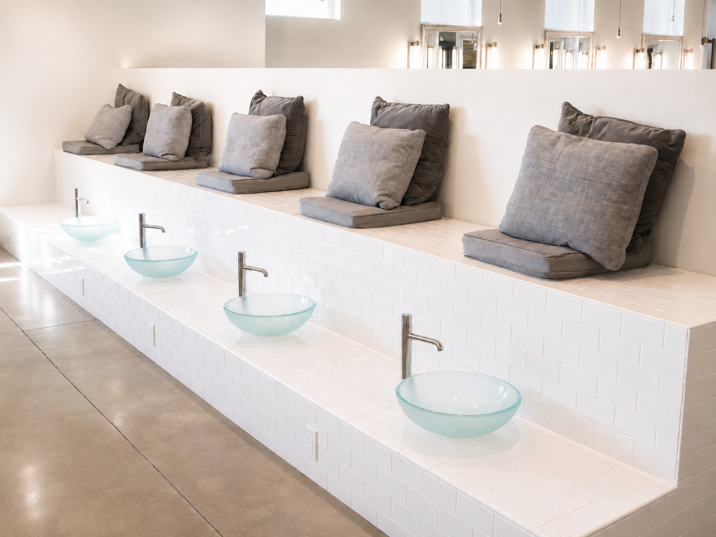 Pedicure training area with built-in seating and glass foot basins