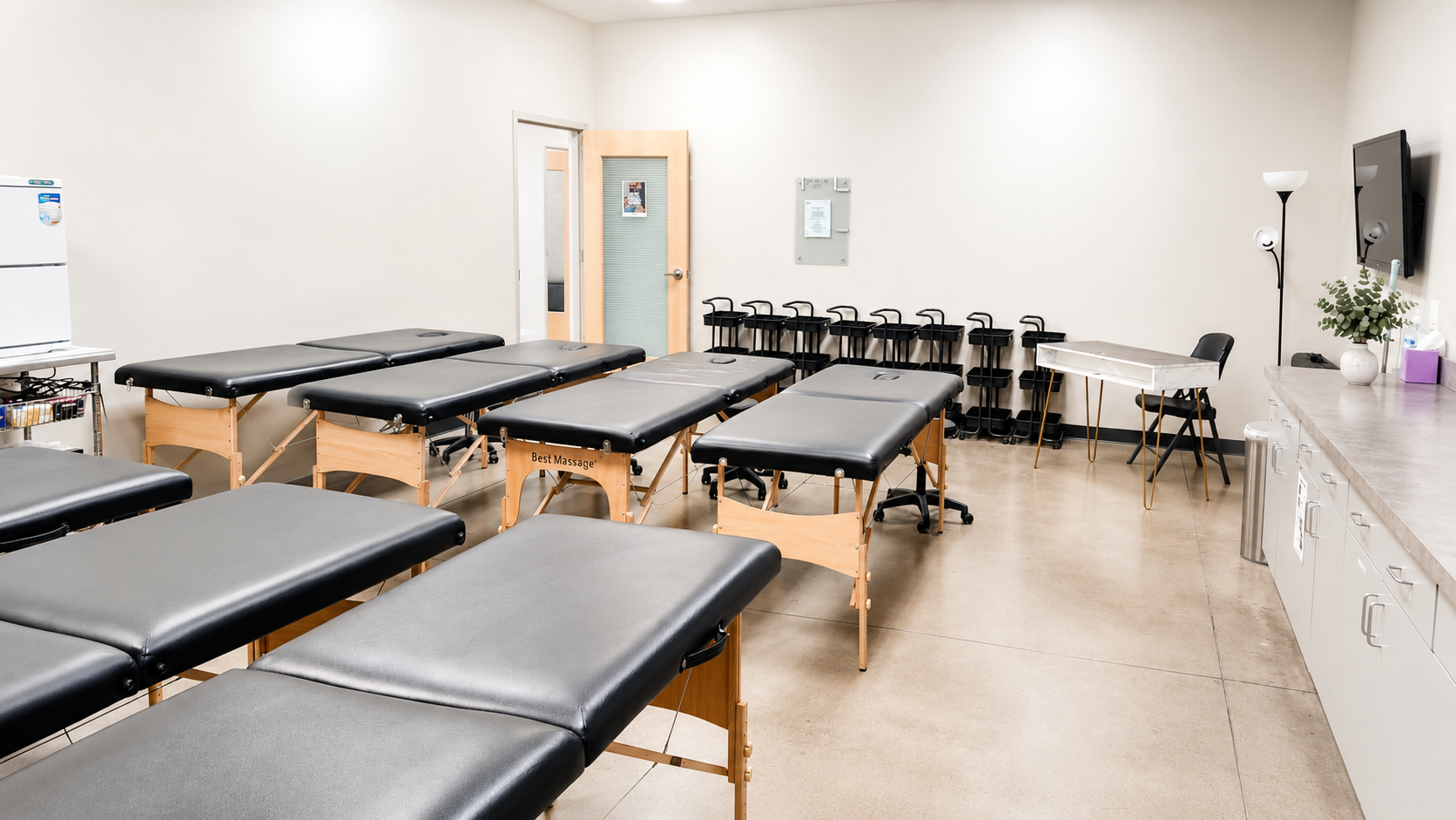 Massage and esthetics training classroom with professional treatment tables